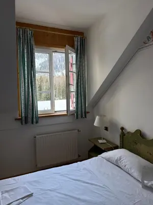 a room with a table and chairs and a living room at Golf Hotel & Spa Carezza - Appartamenti Panoramici direttamente sulle piste da sci in Bolzano