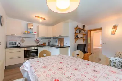 a kitchen with a table and chairs and a dining room at Appartamento Sant Antonio in Canale dʼAgordo