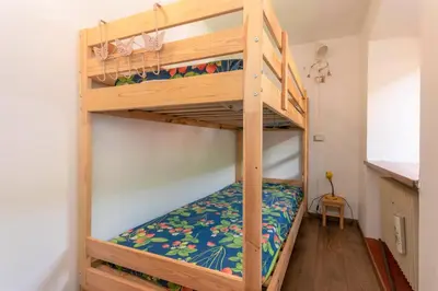 a bunk bed in a small room with a bunk bedsheet at Appartamento Sant Antonio in Canale dʼAgordo