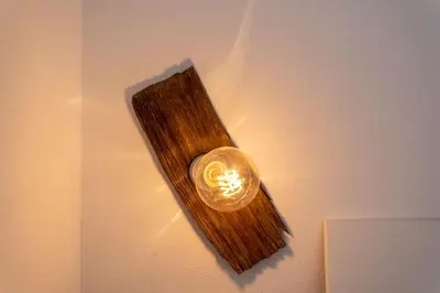a light on a wall with a wooden board at Appartamento Sant Antonio in Canale dʼAgordo