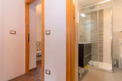 a bathroom with a tv and a glass window at Appartamento Sant Antonio in Canale dʼAgordo