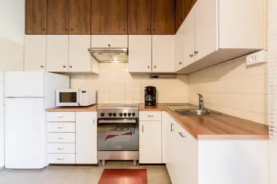 a kitchen with white appliances and wooden cabinets at Apartment Sybille in Merano