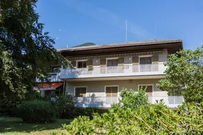 an apartment building with a balcony and trees at Apartment Sybille in Merano