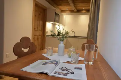 a wooden table with a book and glasses on it at Landhaus Breitenberg in Lana