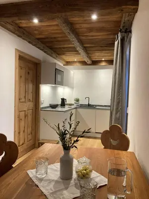 a kitchen with a wooden table with a vase on it at Landhaus Breitenberg in Lana