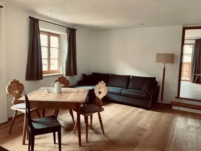 a living room with a table and a couch at Landhaus Breitenberg in Lana