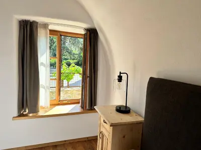 a room with a window and a desk with a lamp at Landhaus Breitenberg in Lana