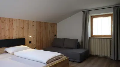 a bedroom with a bed and a couch at Grimmhof in Fiè