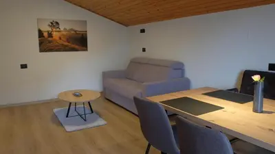 a living room with a table and a couch at Grimmhof in Fiè
