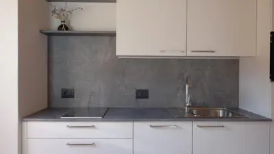 a kitchen with white cabinets and a sink at Grimmhof in Fiè