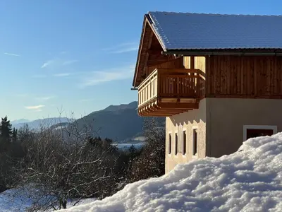 a building with a balcony in the snow at Grimmhof in Fiè