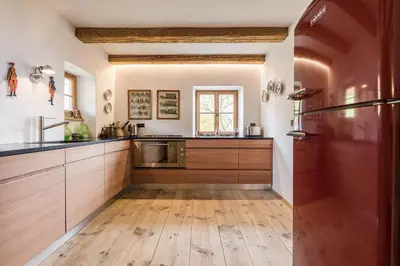 a kitchen with wooden cabinets and a wooden floor at Chalet Sophie in Longomoso