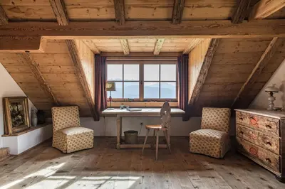 an attic room with a desk and two chairs at Chalet Sophie in Longomoso