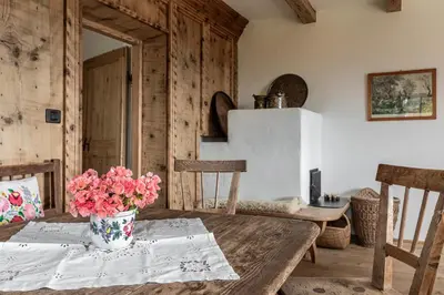 a dining room with a table with flowers on it at Chalet Sophie in Longomoso