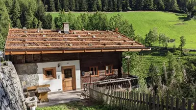 a small house in a field with a fence at Chalet Laugenblick Alpine Luxury with Hot Tub and Sauna in Santa Valburga St. Walburg