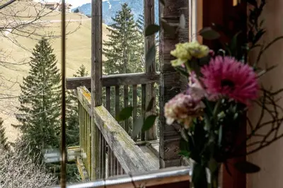 a vase of flowers sitting next to a window at Chalet Laugenblick Alpine Luxury with Hot Tub and Sauna in Santa Valburga St. Walburg