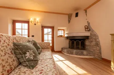 a living room with a couch and a fireplace at Chalet Lagusello in Alleghe