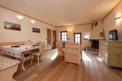 a kitchen with a table and a dining room at Chalet Lagusello in Alleghe