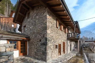 an old stone building with a wooden roof at Chalet Lagusello in Alleghe