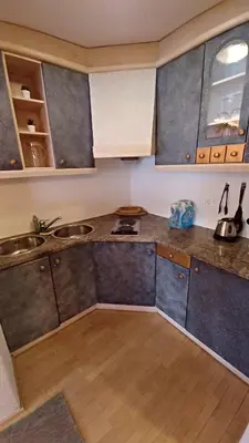 a kitchen with gray cabinets and a wooden floor at Valentino Apartment in Castelrotto