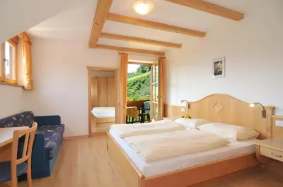 a bedroom with a large bed and a table at Spiegelhof in Appiano sulla Strada del Vino