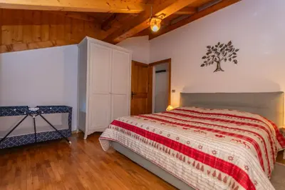 a bedroom with a bed and a tree on the wall at Casa Fagher in Canale dʼAgordo
