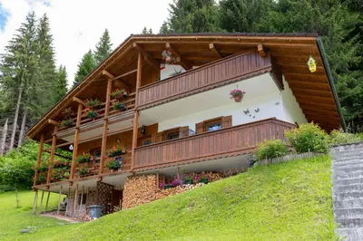 a house on a hill with flowers on the balcony at Casa Fagher in Canale dʼAgordo