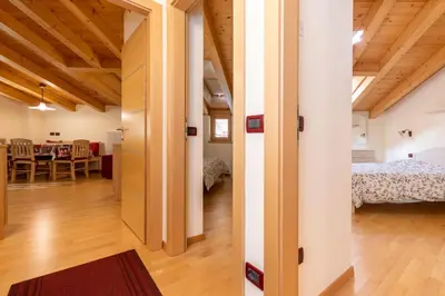 a room with a bedroom and a dining room at Casa Milena in Pozza di Fassa