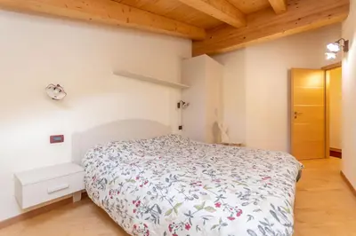 a bedroom with a bed and a wooden ceiling at Casa Milena in Pozza di Fassa