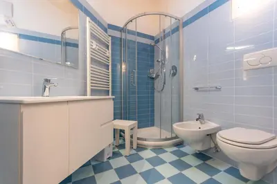 a blue and white bathroom with a toilet and a sink at Casa Milena in Pozza di Fassa