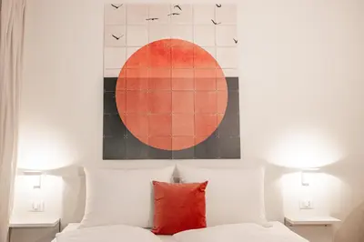 a painting above a bed with a red pillow at Italyescapes Delia in Merano