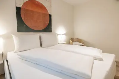 two white beds in a room with a painting on the wall at Italyescapes Delia in Merano