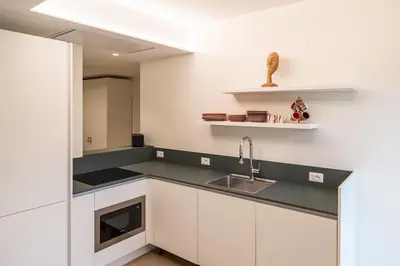 a kitchen with white cabinets and a sink at Italyescapes Delia in Merano