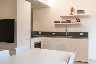 a kitchen with a white table and white chairs at Italyescapes Delia in Merano