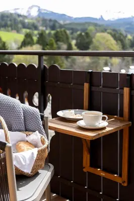 a table with a cup of coffee on a balcony at Michlhaus nature and suites in Aldino