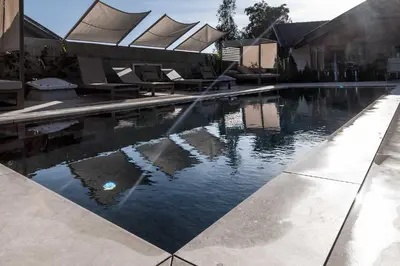 a swimming pool with a fountain in the middle at Michlhaus nature and suites in Aldino