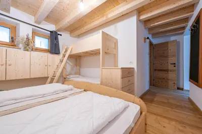 a bedroom with two bunk beds and a ladder at Ciasa Marta in Vigo di Fassa