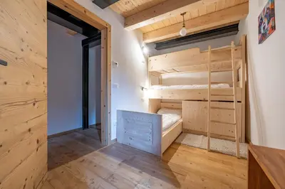a couple of bunk beds in a room with wooden walls at Ciasa Marta in Vigo di Fassa