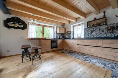 a large kitchen with wooden floors and wooden ceilings at Ciasa Marta in Vigo di Fassa