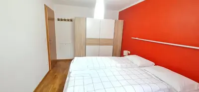 a white bed in a room with a red wall at Casa dei sogni in Valdaora