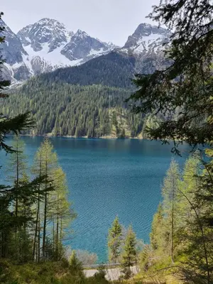 a view of a blue lake with snow covered mountains at Casa dei sogni in Valdaora