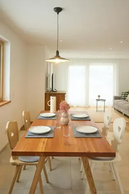 a dining room with a wooden table with chairs at Ciasa Plandros Apartments in La Valle