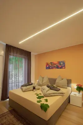 a living room with two couches and a red wall at Garden e Wellness LE VIGNE - relax e luxus in Tesimo