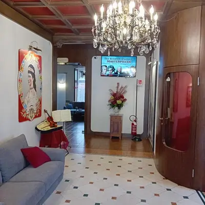 a living room with a couch and a chandelier at Hotel Regina del Bosco in Ronzone