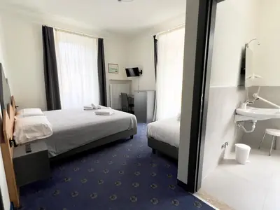 a hotel room with a bed and a sink at Hotel Regina del Bosco in Ronzone