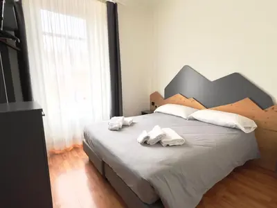 a bedroom with a large bed with towels on it at Hotel Regina del Bosco in Ronzone