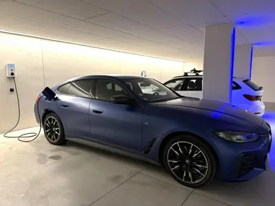 a blue car is plugged into a car charger at Apartsuites Rosengarten in Lagundo