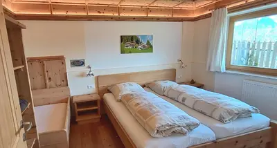 two beds in a small room with a window at Urlaub auf dem Bergbauernhof Gigglhirn in Ulten in Ultimo