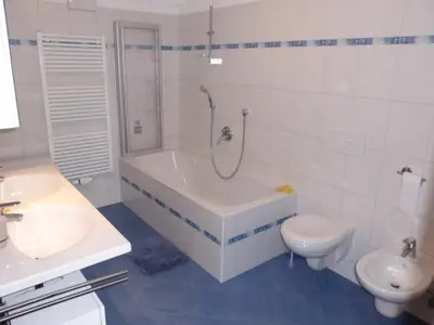a bathroom with a tub and a toilet and a sink at Urlaub auf dem Bergbauernhof Gigglhirn in Ulten in Ultimo