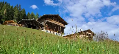 a wooden building on top of a hill at Urlaub auf dem Bergbauernhof Gigglhirn in Ulten in Ultimo